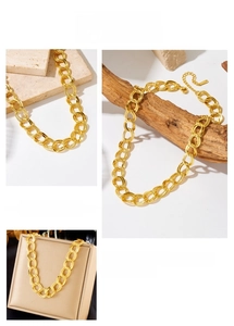 Macro detail of textured gold-plated oval chain links with lobster clasp closure