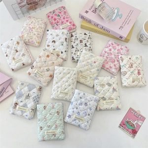 Close-up of quilted floral passport covers in pastel colors with cute animal patterns
