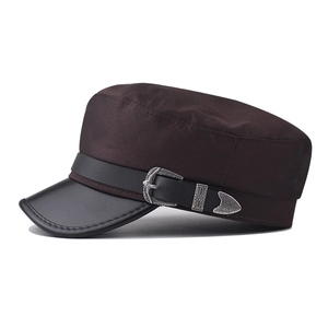 Detail of vintage silver metal buckle and leather strap on dark brown military cap