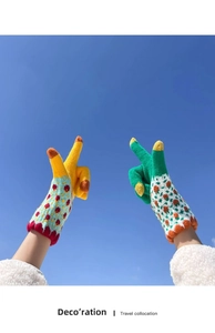 Close-up of colorful jacquard knit touchscreen gloves against a blue sky for winter