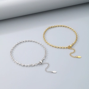 Close-up of minimalist gold and silver link anklets with lobster clasps and extenders