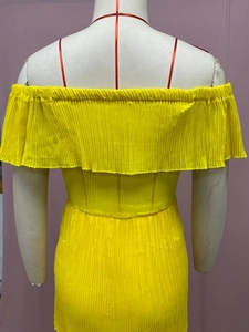 Nahaufnahme des gelben Plissee-Chiffonstoffs und des schulterfreien Ausschnitts am Kleid