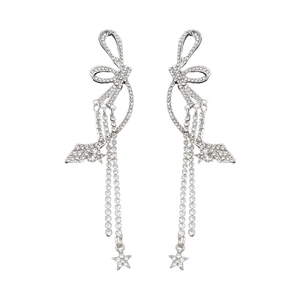 Élégantes boucles d'oreilles nœud et étoile argentées avec strass brillants sur blanc