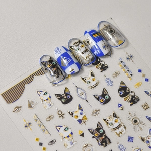 Detail of Egyptian cat and Horus eye gold foil nail stickers for manicure art