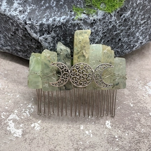 Detail of green moss agate stones and silver triple moon symbol on a metal hair comb