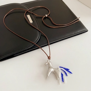 Sautoir en corde cirée avec pendentif cheval argenté et pompon de perles bleues