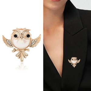Golden owl brooch with pearl and rhinestones shown as product close-up and on black blazer