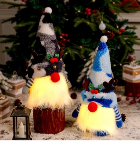 Close-up of glowing LED Christmas gnomes with reindeer antlers and soft plush textures