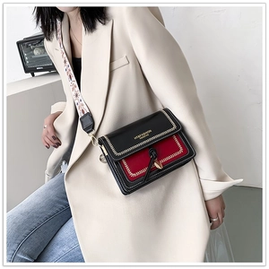 Close-up of contrast color crossbody bag with red拼接 and heart metal buckle detail