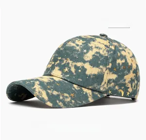 Detail of beige baseball cap featuring gold star and moon embroidery on tie-dye fabric