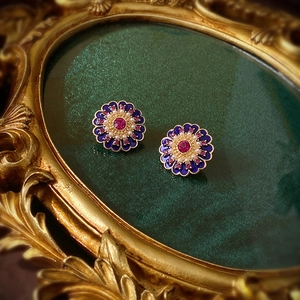 Detail of vintage flower stud earrings with purple enamel petals and pearls
