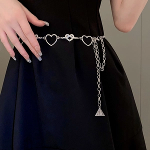 Detailed macro view of heart-shaped hollow metal waist chain with triangular pendant charm