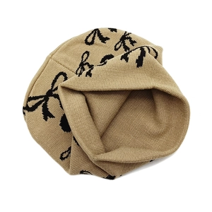 Warm khaki knitted beanie with black bow jacquard pattern for winter outdoor styling