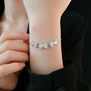 Adjustable silver bracelet featuring three zircon-encrusted bows on a model wrist
