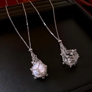 Elegant silver necklace with pearl and crystal ball pendants in intricate metal mesh