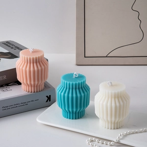 Modern pleated pillar candles in pink, teal and white on a tray for home decor