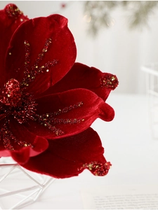 Close-up of red velvet Christmas flower with gold glitter and sequins decoration