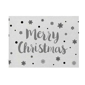 Detail of linen texture placemat with Merry Christmas print and snowflake patterns