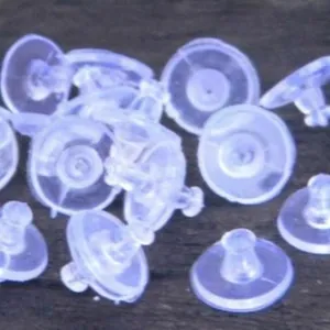 Clear silicone saucer earring backs set for stud earrings on dark wood background