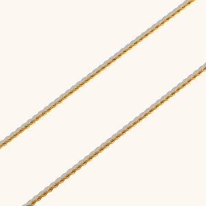 Détail de la chaîne torsadée en acier inoxydable doré avec texture métallique tressée
