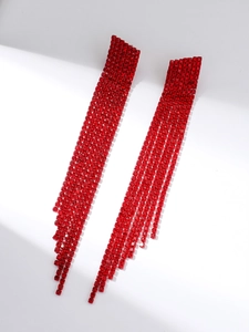 Macro view of long tassel earrings with sparkling red rhinestones and elegant details