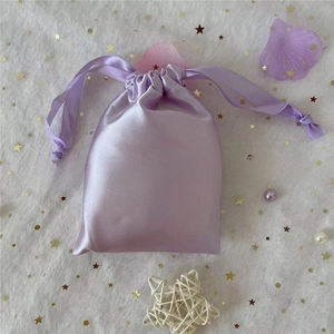 Detail of lilac satin drawstring gift bag with smooth silk texture and dual ribbons