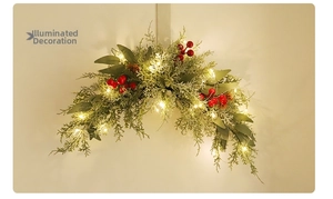 Detail of light-up Christmas swag with red berries and warm LED lights on pine needles