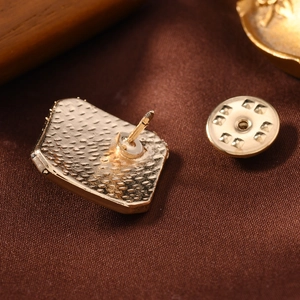 Close-up of golden floral brooch with textured finish and butterfly clutch back