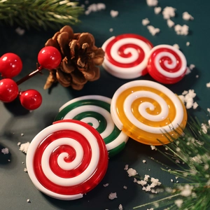 Christmas swirl candy tree ornaments with peppermint design on pine needles and snow