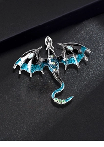 Detailed view of the intricate dragon brooch with blue enamel and colorful gemstones