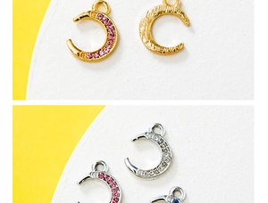Detailed macro view of colorful crescent moon charms with sparkling gemstone inlays