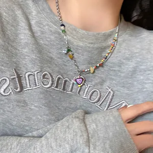 Close-up of a Y2K style colorful beaded heart necklace with purple crystal pendant