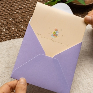 Hands holding a 3D floral greeting card with purple envelope and hope text
