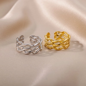 Macro view of woven hollow Cuban chain rings in gold and silver stainless steel