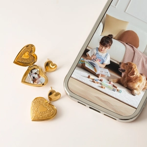 Detail of vintage heart locket earrings in gold finish with a small photo insert inside
