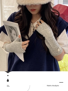 Close-up of light grey knitted fingerless gloves with nice label and soft texture