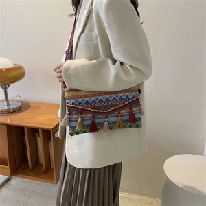 Detail view of Bohemian crossbody bag with colorful weaving and ethnic tassel accents