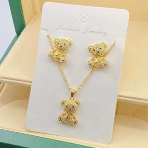 Detailed view of sparkling teddy bear necklace and earrings set in a green jewelry box
