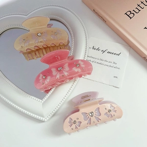 Close-up of elegant acetate butterfly hair claws with rhinestones in pink and champagne
