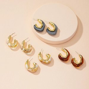 Detailed close-up of multi-color acrylic and metal C-shaped earrings in retro geometric style
