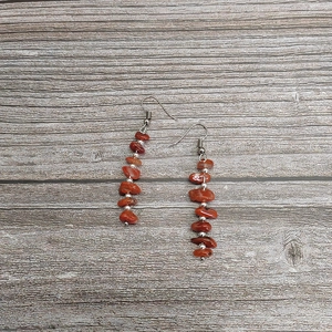Detail of bohemian drop earrings with red natural crystal beads and silver spacers