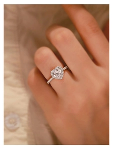 Macro detail of S925 sterling silver heart-shaped halo moissanite engagement ring on finger