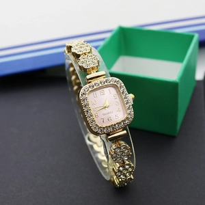 Vue détaillée d'une montre carrée dorée avec strass et bracelet métallique en forme de fleur