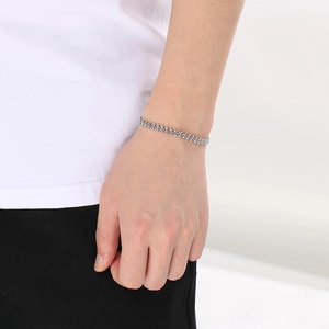 Close-up of a stylish silver wheat chain bracelet worn on a wrist for a trendy look