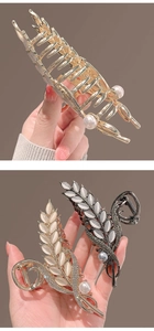 Detail of golden wheat-shaped hair claw clips with cat-eye stones and tiny pearls