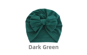 Detail view of dark green baby turban hat with a large decorative bow and soft ribbed texture