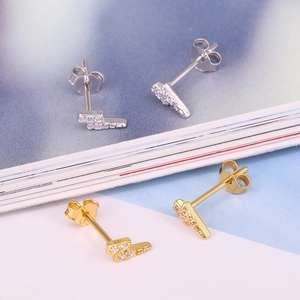 Close-up of S925 sterling silver lightning bolt stud earrings with cubic zirconia in gold and silver
