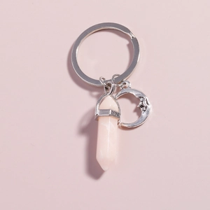 Detailed view of pink hexagonal crystal column and silver moon charms on key ring