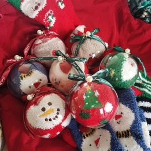 Detail of Christmas fuzzy socks inside transparent gift ornaments with decorative ribbons