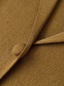 Gros plan de la texture en maille et bouton recouvert de tissu sur le cardigan en détail